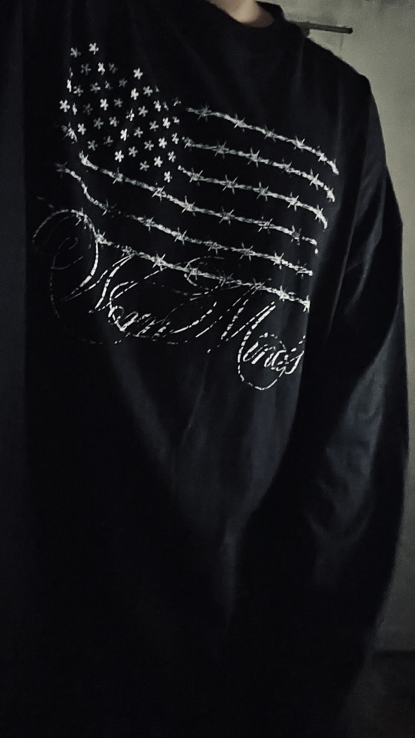 Detalle de una camiseta negra con bordado blanco